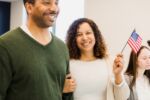 Happy Multiracial Couple Holding American Flag, Indoor Portrait