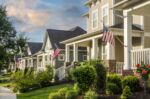 American Flags hang from the front of this traditional, brick homes in an All-American neighborhood.